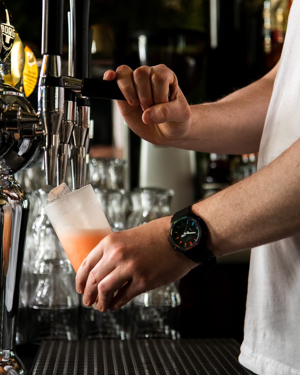 Barþjónn að dæla kokteil úr krana